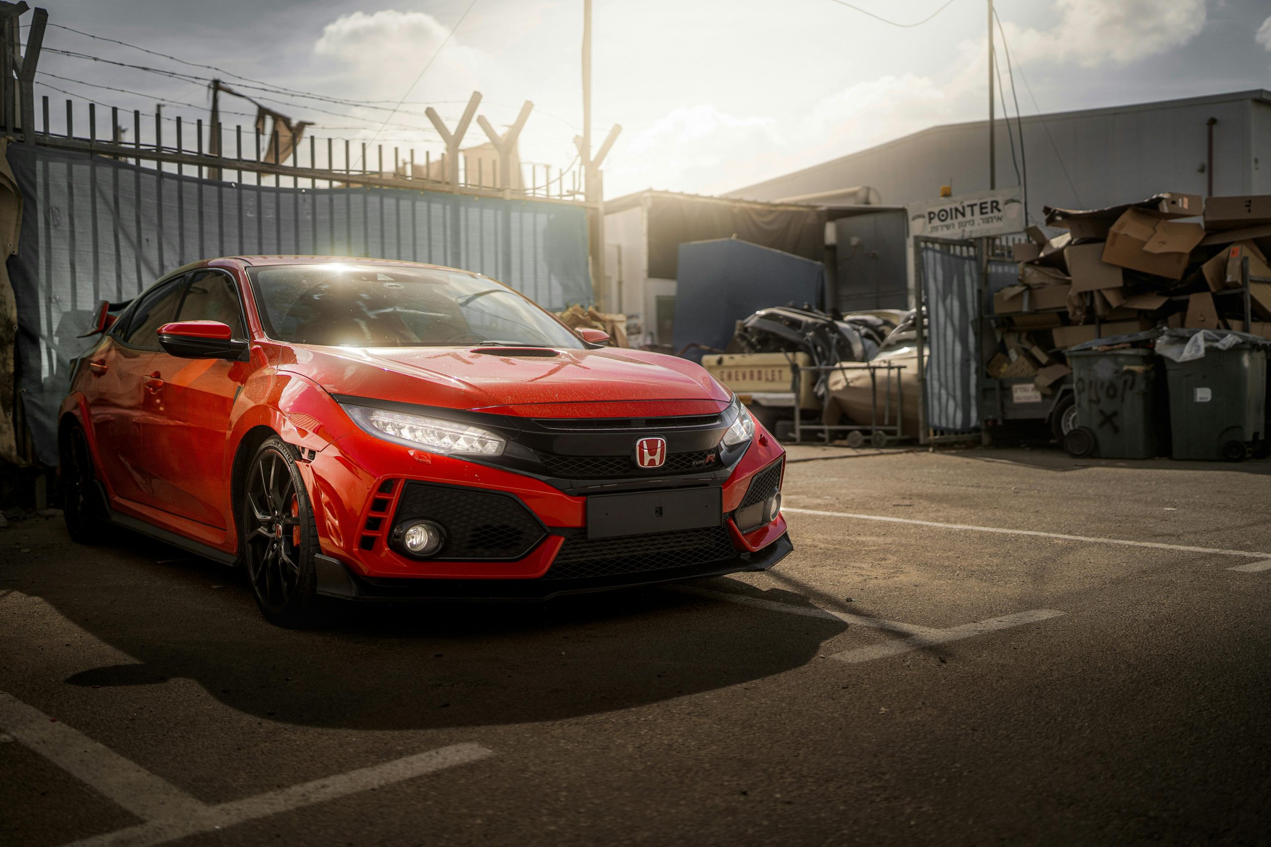 Dynamic shot of a red Honda Civic Type R parked in an urban Cyprus environment during the day.
